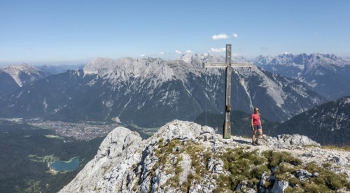 Hiker at the summit cross, Westliche Wettersteinspitze, rear Karwendel, Bavaria, Germany, Europe