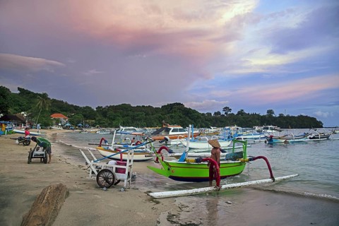 Balinese fishermen with traditional outrigger fishing boats in the bay of Padang Bai, Padangbai,