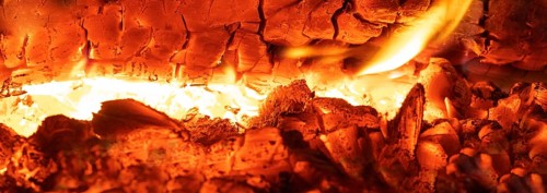Glowing flames in the tiled stove, open fire