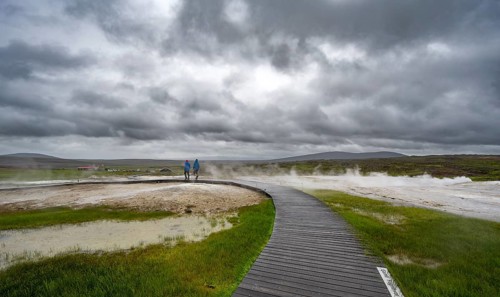 Tourists on a wooden path, steaming hot springs, Hveravellir geothermal area, Icelandic highlands,