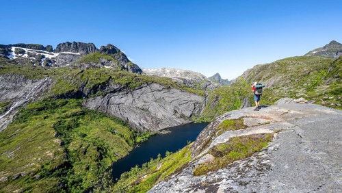 Mountaineers on the hiking trail to Munkebu hut, view of lake Tridalsvatnet and mountain landscape,