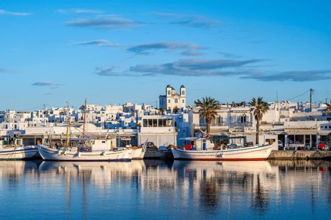 View of Naoussa, Fishing boats in the harbour at sunset, reflected in the sea, White Cycladic