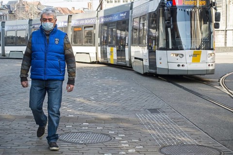 Tram and man wearing medical face mask due to 2020 COVID-19, coronavirus, corona virus pandemic