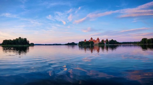 Panorama of Trakai Island Castle in lake Galve, Lithuania on sunset with dramatic sky reflecting in