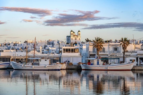 View of Naoussa, Fishing boats in the harbour at sunset, reflected in the sea, White Cycladic