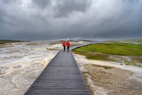 Tourists on a logging road between hot springs, Hveravellir geothermal area, Icelandic Highlands,