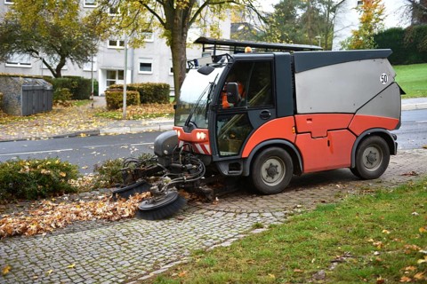 Sweeper sweeping wilted leaves in autumn, Vellmar, Hesse, Germany, Europe