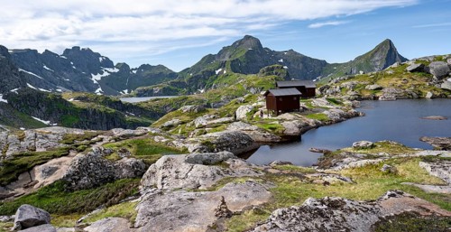 Mountain hut Munkebu hut by a small lake, mountain landscape with rocky peaks and lakes,