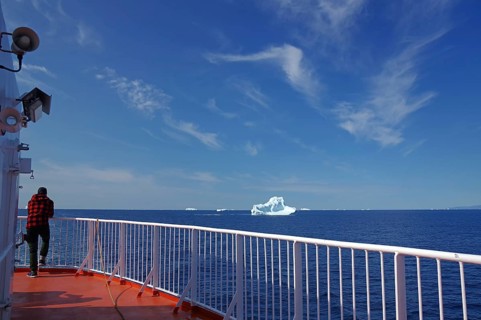 Man standing at the railing of a passenger ferry, icebergs, icebergs, Ilulissat, Disko Bay,