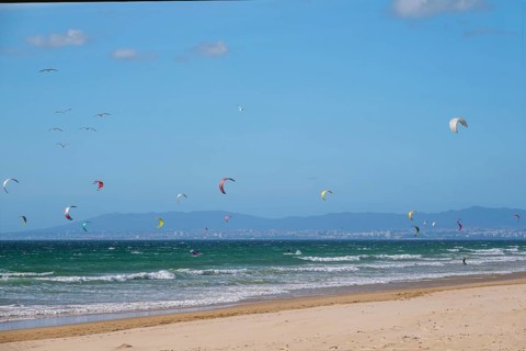 Kiteboarding kitesurfing kiteboarder kitesurfer kites on the Atlantic ocean beach at Fonte da Telha