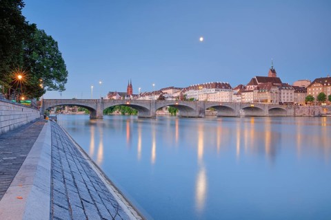 View of the old town of Basel illuminated at night with the Basel Cathedral, St. Martin's Church,