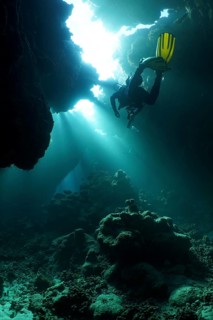 Diver swimming in cave, underwater, light rays, sun rays, St Johns Caves dive site, Saint Johns