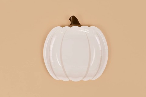 Simple pumpkin shaped party paper plate on beige background