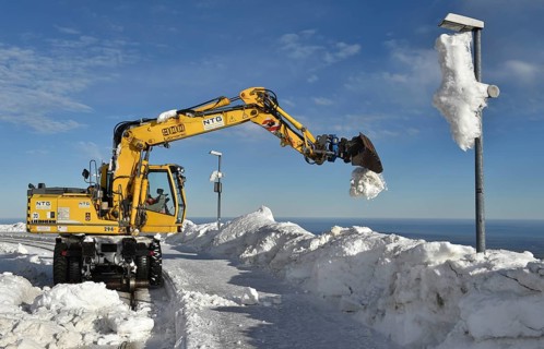 Two-way excavator clears the tracks of snow at Brocken railway station in the Harz mountains,