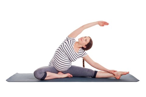 Pregnancy yoga exercise, pregnant woman doing asana Parivrtta janu sirsasana head to knee pose