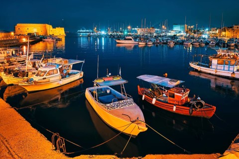 Venetian Fort castle in Heraklion and moored Greek fishing boats in port, Crete Island, Greece in