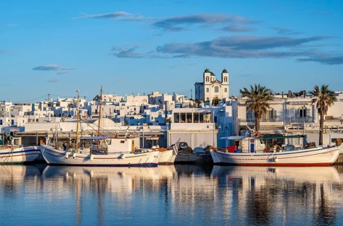 View of Naoussa, Fishing boats in the harbour at sunset, reflected in the sea, White Cycladic