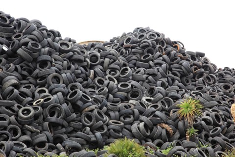 Old car tyres lie on stockpiles for recycling