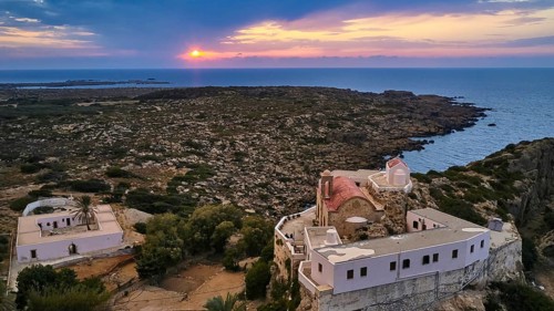 Drone shot, dusk, sunset, cloudy sky, square yard, sea, Chrissoskalitissa, rock monastery, Orthodox