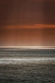 Sunbeams through cloud cover, sunlight glistening on the sea, evening sky, motion blur,