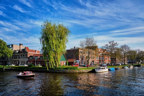 HAARLEM, NETHERLANDS, MAY 6, 2017: Boat in canal and houses. Harlem, Netherlands