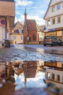 Street through the half-timbered town, historical building with reflection in puddle,