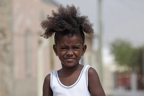 Close up portrait of Creole girl with frizzy hair on the island Boa Vista, Cape Verde, Cabo Verde,
