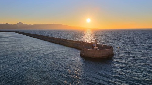 Evening light, sunset, harbour light, harbour wall, mountains, blue and orange sky, harbour,