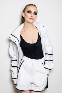 Portrait of fashion model in white sports suit. Girl in unzipped jacket, sleeveless t-shirt and