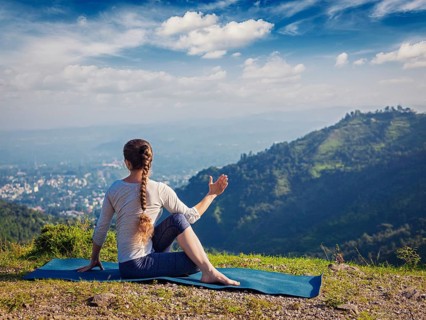 Hatha yoga outdoors, woman doing yoga asana Parivrtta Marichyasana (or ardha matsyendrasana),