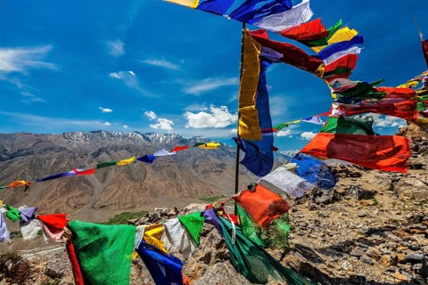Buddhist prayer flags lungta with Om mani padme hum mantra written on them in Spiti Valley in