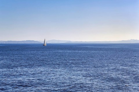 Strait, Strait of Bonifacio, sailboat in front of Sardinia Island on horizon, blue sky,