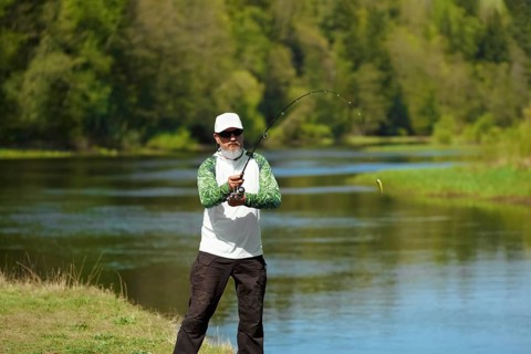 Fisherman trying to do a perfect cast, throwing lure. Spining fishing, angling, catching fish.
