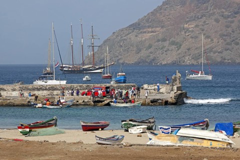 Colourful fishing boats and Creole fishermen in front of the three-masted topsail schooner