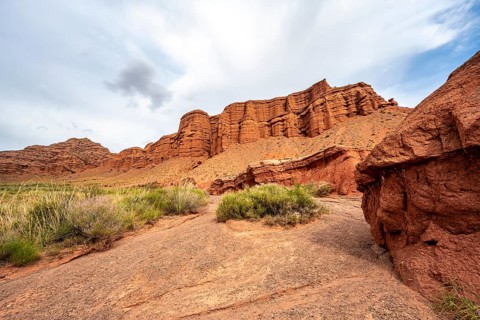Eroded mountain landscape with sandstone cliffs, red and orange rock formations, Konorchek Canyon,