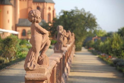 Row of red putti, putti on the balustrade in the garden of the monastery complex, red, sculptures,