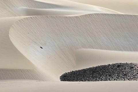 Dunes formed by blown in Sahara desert sand and volcanic rocks in the Deserto de Viana desert on