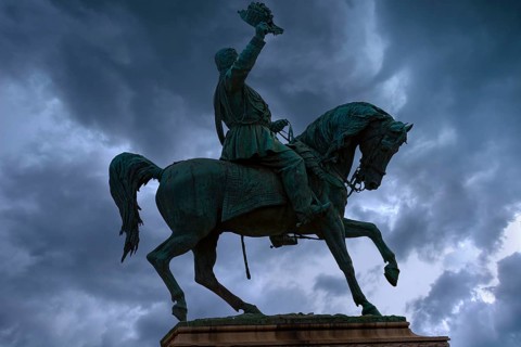 Silhouette of the equestrian statue of King Vittorio Emanuele III, rain clouds, Piazza Corvetto,