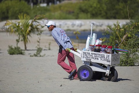 Beach vendor pulling cart with drinks at Playa Principal near Puerto Escondido, San Pedro Mixtepec,