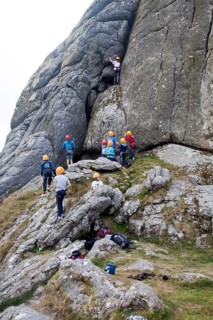 Children rock climbing on the granite tor of Haytor, Dartmoor national park, Devon, England, UK