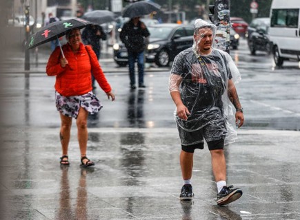 Tourists with rain capes and umbrellas during heavy rainfall, Berlin, 23 06 2023