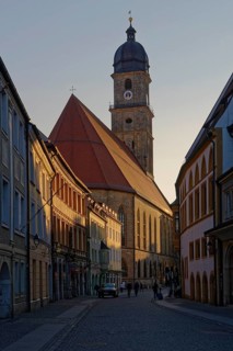 The setting sun colours the sky above an old town church Basilica of St. Martin, Rathausgasse,