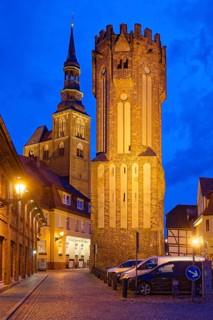 The Owl Tower at Hühnerdorfer Tor, built in brick Gothic style and illuminated at night, in the old