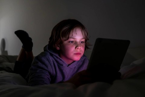 A boy plays computer games on a tablet PC
