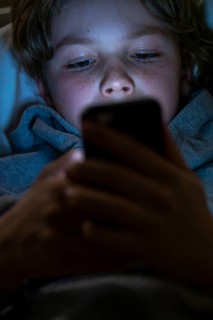 A boy plays computer games on a mobile phone, smartphone
