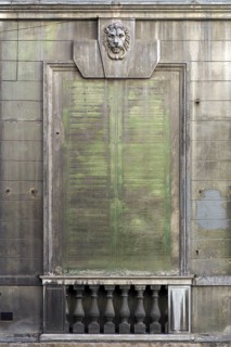 Lion's head above an emission-soiled window of an abandoned palazzo, historic centre, Genoa, Italy,