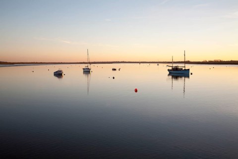 Boats at moorings at sunset on the River Deben, Ramsholt, Suffolk, England, United Kingdom, Europe