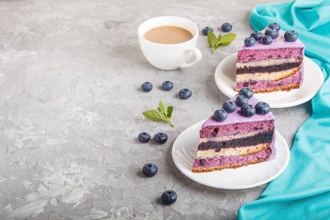 Homemade cake with souffle cream and blueberry jam with cup of coffee and fresh blueberries on a