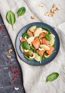 Fresh salmon with pineapple, spinach and cashew on a black concrete background. Top view, flat lay,