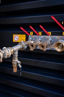 Metal pipeline with red valves and safety markings on a wall, fibreglass construction, Nagold,